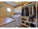 Spacious laundry room with modern washer, dryer, shelving, and a convenient folding counter at 6483 Royal Oakland Dr, Indianapolis, IN 46236