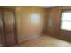 Bedroom with hardwood floors, wood paneling, one window, and dark colored door at 6484 S State Road 39, Clayton, IN 46118