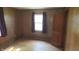 Bedroom with wood paneling, hardwood floors, and a large window with purple drapes at 6484 S State Road 39, Clayton, IN 46118
