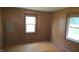 Cozy bedroom with hardwood floors, wood paneling, and natural light from two windows at 6484 S State Road 39, Clayton, IN 46118