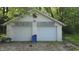 The two-car detached garage has white doors and is surrounded by trees at 6484 S State Road 39, Clayton, IN 46118