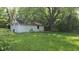 Side view of a white detached garage on a sunny day with lush green trees at 6484 S State Road 39, Clayton, IN 46118