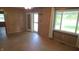 Large living room with hardwood floors, wood paneled walls, large windows and glass paned door at 6484 S State Road 39, Clayton, IN 46118
