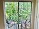 A private balcony featuring a table and chairs with a view of lush green trees at 6927 Havenmoor Pl, Indianapolis, IN 46250