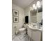Clean bathroom with a white vanity, decorative prints, and marble-patterned floors at 6927 Havenmoor Pl, Indianapolis, IN 46250