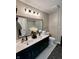Bathroom with dual sink vanity, framed mirror, panelled accent wall, and glass-enclosed shower at 6927 Havenmoor Pl, Indianapolis, IN 46250