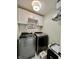 Laundry room with front-load washer and dryer, overhead cabinets, and white subway tile backsplash at 6927 Havenmoor Pl, Indianapolis, IN 46250