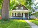 Charming two-story brown home featuring colorful flowers in the front yard at 706 N Euclid Ave, Indianapolis, IN 46201