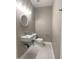 Modern powder room with a wall-mounted sink and round mirror at 706 N Euclid Ave, Indianapolis, IN 46201