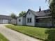View of single story house with driveway and garage behind the fence on a sunny day at 707 S Harrison St, Alexandria, IN 46001