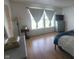 Bright bedroom with a large window, dresser, and wood-look flooring at 713 Driftwood Cir, Danville, IN 46122