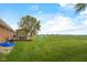 Large backyard with a spacious lawn, wooden deck with seating, and a colorful playhouse at 762 N Dellasburg Rd, Columbus, IN 47203