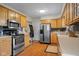 Practical kitchen featuring stainless steel appliances, wood cabinets, and stone backsplash at 762 N Dellasburg Rd, Columbus, IN 47203