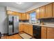 Well-lit kitchen featuring stainless steel appliances, wood cabinets, and stone backsplash at 762 N Dellasburg Rd, Columbus, IN 47203