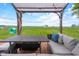 Cozy outdoor seating area with pergola, comfortable furniture, and a view of the expansive green lawn at 762 N Dellasburg Rd, Columbus, IN 47203