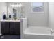 Bright bathroom featuring a large mirror, soaking tub and modern fixtures at 7834 Fairwood Blvd, Plainfield, IN 46168