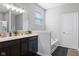 Bathroom featuring dual vanities, a soaking tub, and a window for natural light at 7834 Fairwood Blvd, Plainfield, IN 46168