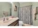 Well-lit bathroom with a patterned shower curtain, vanity, and neutral-toned walls at 8044 Yarmouth Way, Indianapolis, IN 46239