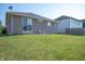 Well-maintained backyard with a small patio, lush green grass, and home's brown vinyl siding at 8199 Sydney Ln, Avon, IN 46123