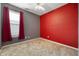 Bedroom with red accent wall, a ceiling fan, and window with red curtains providing ample natural light at 8199 Sydney Ln, Avon, IN 46123