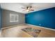 A modern bedroom with hardwood floors, blue accent wall, ceiling fan and natural light from window at 8199 Sydney Ln, Avon, IN 46123