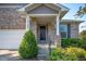 Inviting front porch with manicured shrubbery, columns, and a black front door at 8199 Sydney Ln, Avon, IN 46123