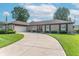 Charming brick ranch home with lush lawn, curved driveway, and attached two car garage at 8209 Burn Ct, Indianapolis, IN 46217