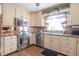 A kitchen with cream-colored cabinets features stainless steel appliances and a tiled backsplash at 8209 Burn Ct, Indianapolis, IN 46217