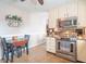 This kitchen features stainless steel appliances, tile floors, a dining table, and cream colored cabinets at 8209 Burn Ct, Indianapolis, IN 46217