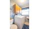 Functional laundry room with wood cabinets, washer, dryer, and sink with bright natural light from the window at 8209 Burn Ct, Indianapolis, IN 46217