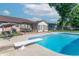 An in-ground pool with a diving board sits in a fenced-in yard, next to a house with a covered patio and plenty of room to entertain at 8209 Burn Ct, Indianapolis, IN 46217