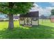 This storage shed is painted tan with brown trim and includes two windows, a single door, and a small deck at the entrance at 8209 Burn Ct, Indianapolis, IN 46217