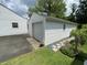 Exterior view of the one-car garage with vinyl siding and garden at 828 N Clarkdale Dr, Muncie, IN 47304