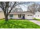 Well maintained single-story home with front lawn, driveway and mature trees in residential neighborhood at 829 Meadow Ln, Greenfield, IN 46140