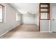 Open-concept living room with built-in shelving connecting to a dining space with new flooring and ceiling fan at 829 Meadow Ln, Greenfield, IN 46140