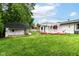 Landscaped backyard featuring a deck with a pergola and a charming playhouse at 8445 Montery Rd, Indianapolis, IN 46226