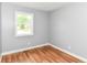 A simple bedroom with hardwood floors, light gray paint, and a window at 8445 Montery Rd, Indianapolis, IN 46226