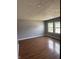 Bedroom with hardwood floors, neutral paint, and windows overlooking a well-maintained street at 8445 Montery Rd, Indianapolis, IN 46226