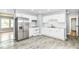 Bright kitchen features stainless steel refrigerator, white cabinetry, and modern flooring at 8445 Montery Rd, Indianapolis, IN 46226