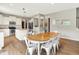 Bright dining room with white chairs, wood table, hardwood floors, and an open layout to the kitchen at 848 Silverheels Dr, Westfield, IN 46074