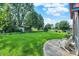 Relax in the lush backyard oasis with mature trees, complemented by a stone patio and inviting white Adirondack chairs at 8619 Wrangler Ct, Indianapolis, IN 46217