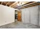 Unfinished basement area with concrete walls, exposed ceiling, and a door leading to storage at 8619 Wrangler Ct, Indianapolis, IN 46217