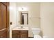 Cozy half bathroom featuring a wood vanity with marble countertop and a classic porcelain toilet at 8619 Wrangler Ct, Indianapolis, IN 46217