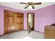 Bedroom featuring light purple walls, plush carpet, a ceiling fan, and a closet at 8619 Wrangler Ct, Indianapolis, IN 46217