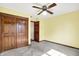 Bedroom with a ceiling fan, carpet flooring, and wooden closet doors at 8619 Wrangler Ct, Indianapolis, IN 46217