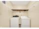 Functional laundry room with white appliances and wire shelving for organized storage at 8619 Wrangler Ct, Indianapolis, IN 46217