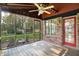 Inviting screened porch with wood flooring, seating and views of the backyard and mature trees at 8619 Wrangler Ct, Indianapolis, IN 46217