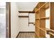 Spacious walk-in closet with custom shelving and wood-look flooring located adjacent to a bathroom at 8619 Wrangler Ct, Indianapolis, IN 46217