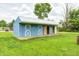 Charming blue outbuilding with white trim and double doors, set in a lush green lawn at 8879 W County Road 700 S, Coatesville, IN 46121