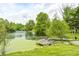 Picturesque pond with a wooden dock, surrounded by lush greenery and mature trees at 8879 W County Road 700 S, Coatesville, IN 46121